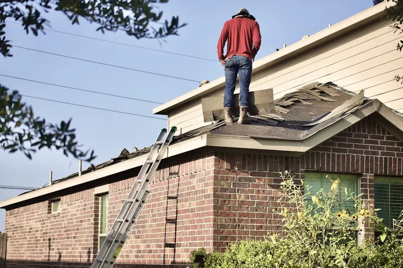 Professional roofer working on a residential roof in Acosta